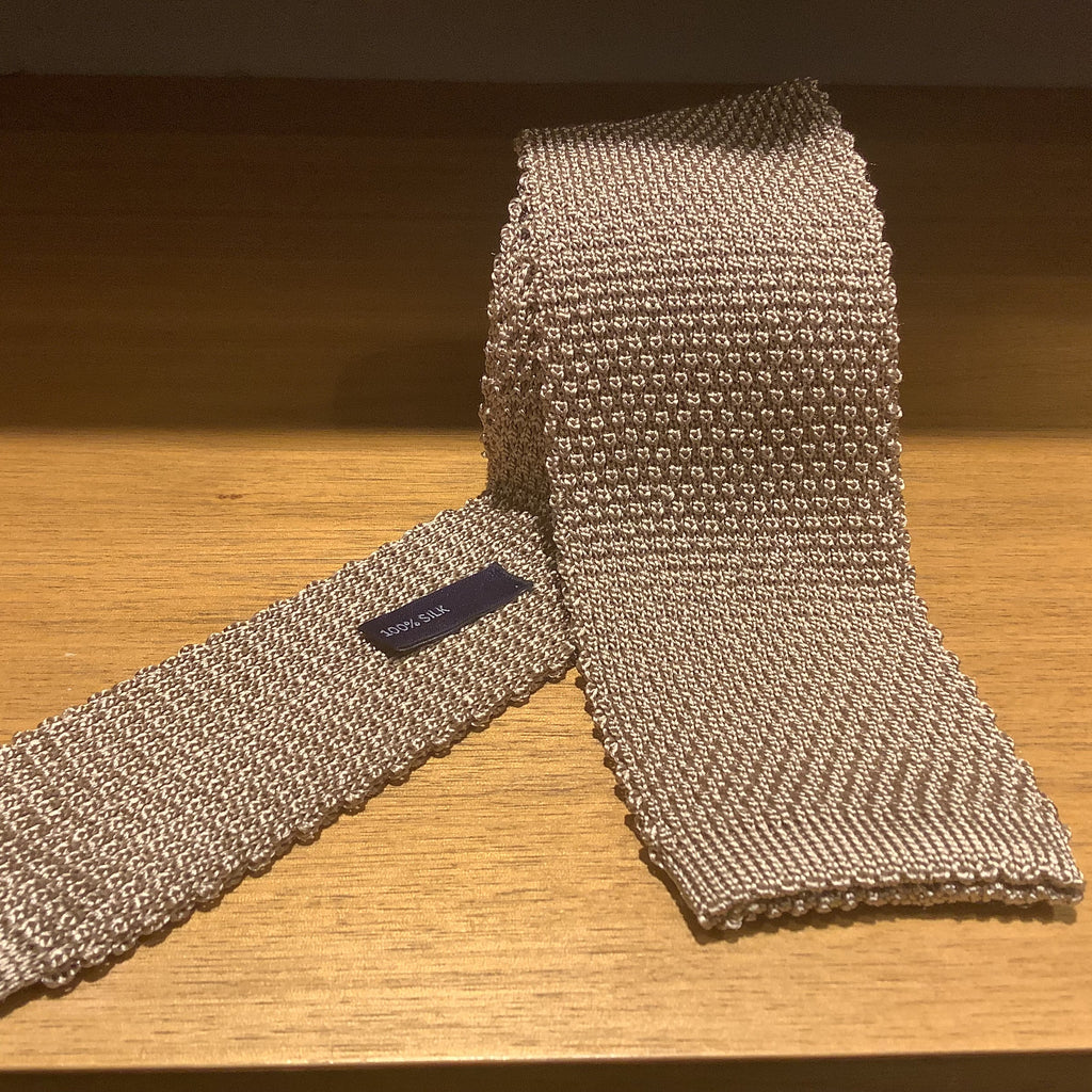 A knit tie with a textured pattern.